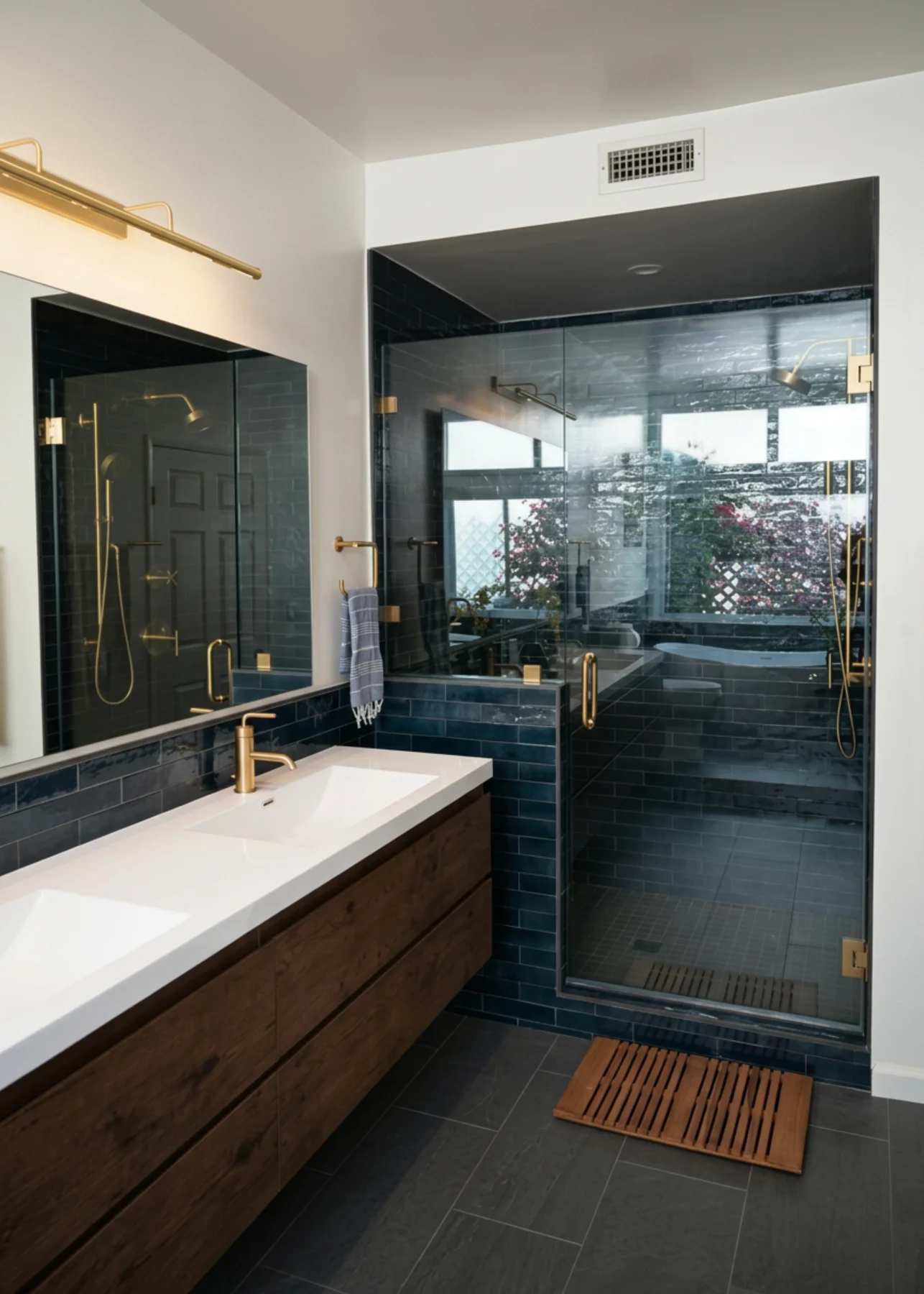 Deep blue tiled bathroom with brass fixtures and a walk-in glass shower, Crowley project